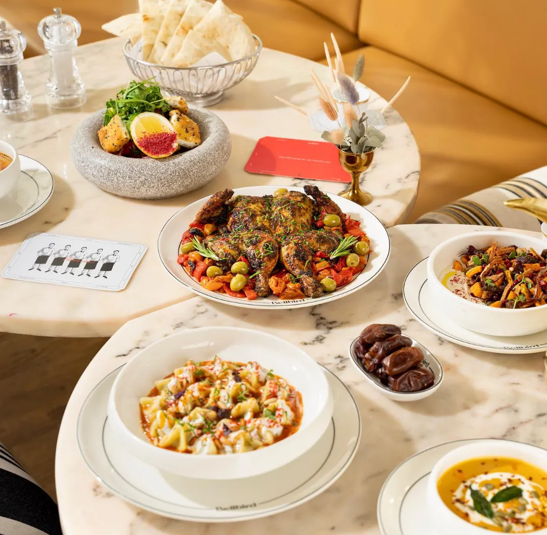 A table set with Middle Eastern-inspired dishes, featuring vibrant colors and elegant plating.