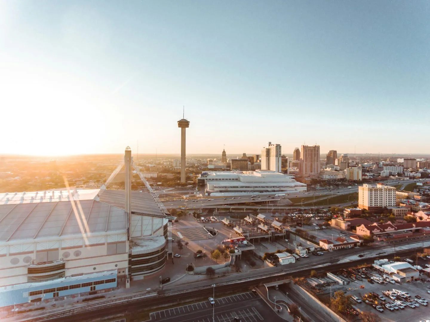 San Antonio skyline at sunrise, featuring the Tower of the Americas and Alamodome.