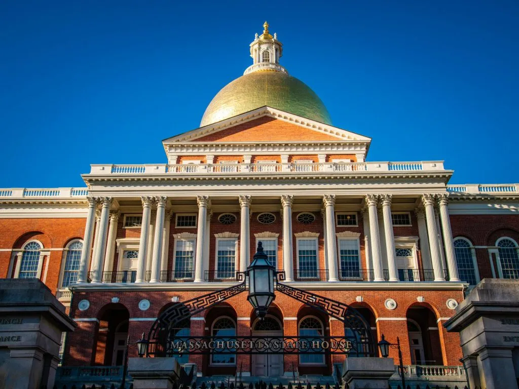 Massachusetts State House with a golden dome, red brick facade, and classical architectural columns.