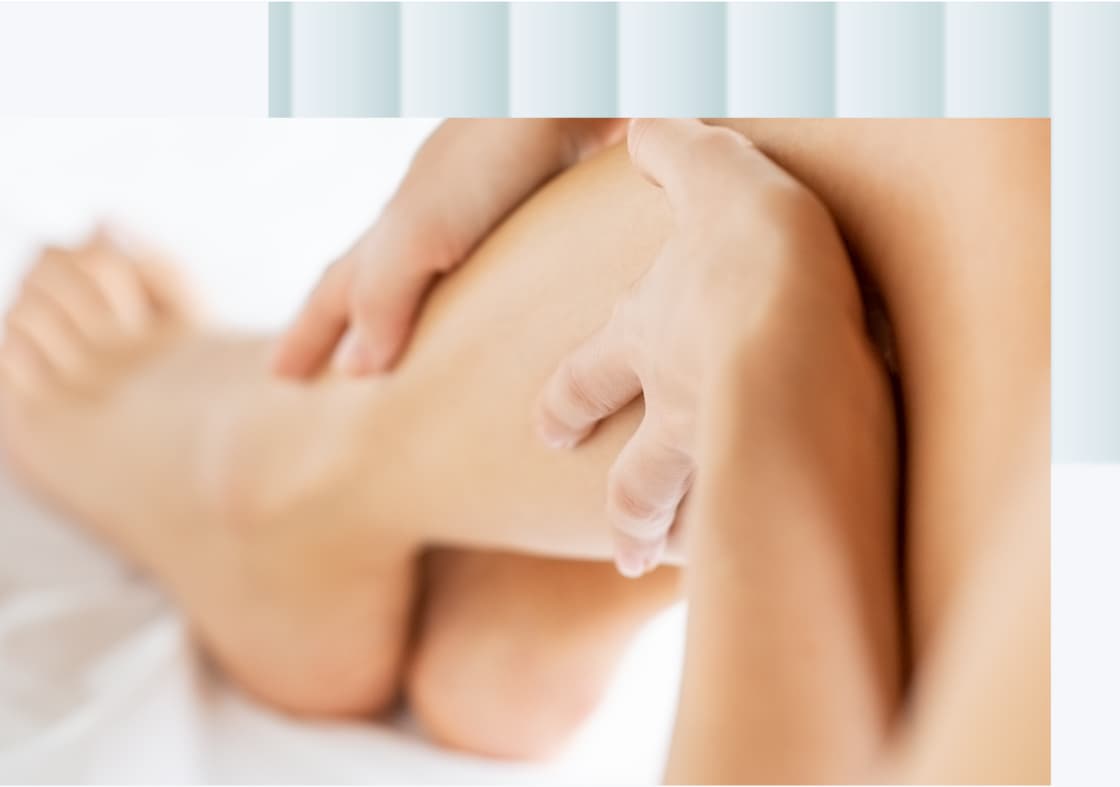 A close-up of a person's hand gently massaging the calf of a leg.