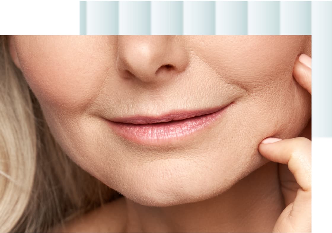 A close-up image of a woman's face featuring her lips and chin, with her hand gently touching her face.