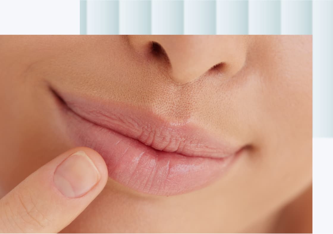 A close-up of a person's lips with a finger gently touching them, showcasing smooth, natural lips.