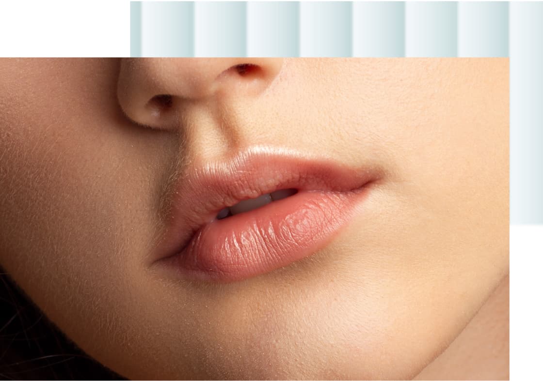 A close-up of a person's lips with a natural pink hue, displaying smooth skin and a subtle shine.