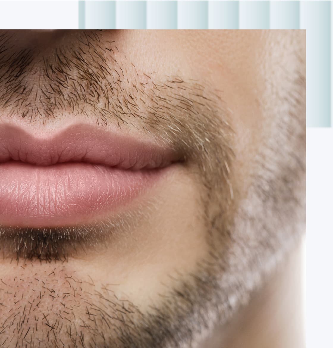 A close-up image of a man's lips and chin, showing light stubble and a natural pink lip color.