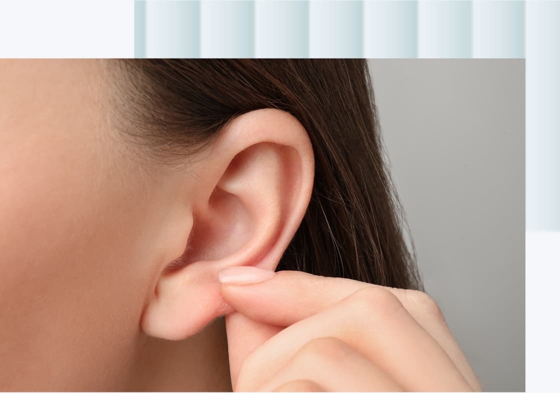 A close-up of a person's ear, with a hand gently pulling on the earlobe.