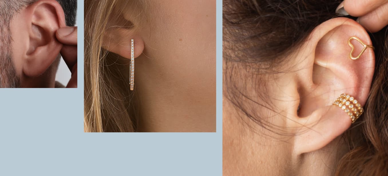 A close-up of a person's ear adorned with multiple earrings: a gold hoop earring shaped like a heart, a long gold earring with a line of small gems, and a gold cuff earring with a pearl design.