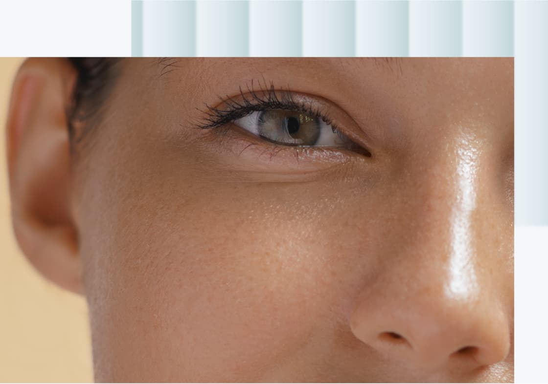 A close-up of a woman's face, focusing on her eye, showcasing natural skin texture and a soft expression.