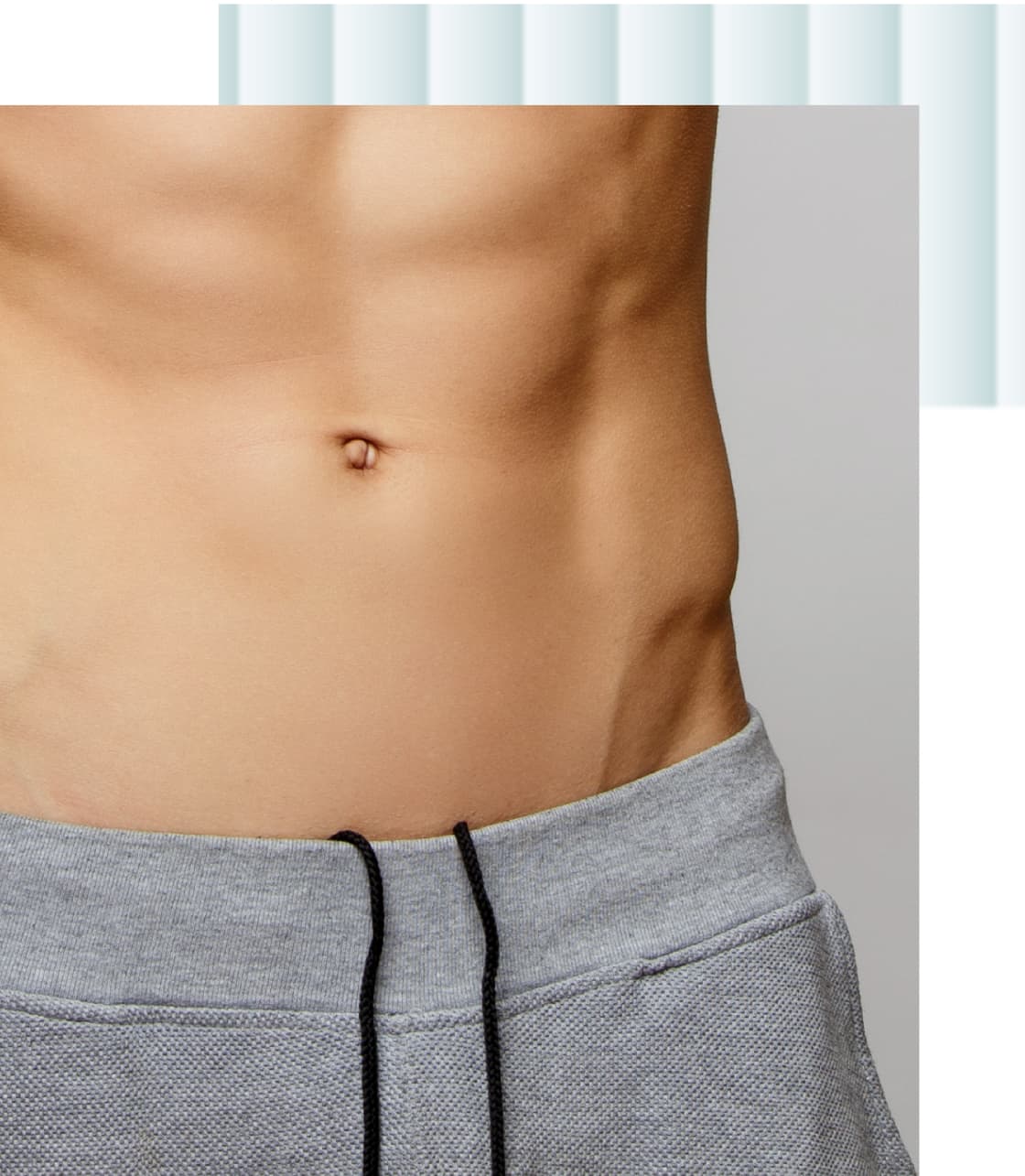 A close-up of a male abdomen featuring defined muscles and a light shadow around the belly button. The subject is wearing gray sweatpants.