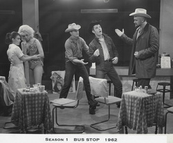 Five people, 2 with cowboy hats, small tables + chairs, 2 of 4 pillars.