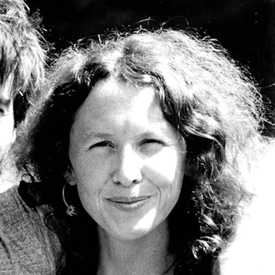 Black and white portrait of a woman with curly hair smiling softly