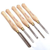 Set of six wood chisels with wooden handles and metal blades arranged in a row.