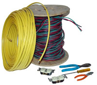 Coils of yellow and colorful electrical wires with connectors and tools on white background