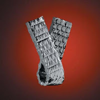 White cylindrical tube made of stacked metal discs against red background