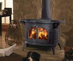Black wood-burning stove with glowing fire and flames inside