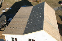 Aerial view of two solar panel arrays on a beige building roof