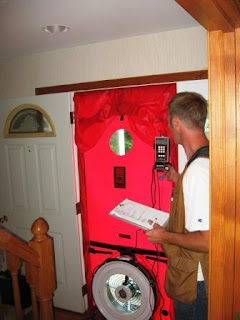 Man standing beside large red emergency equipment door with digital display panel mounted on wall.