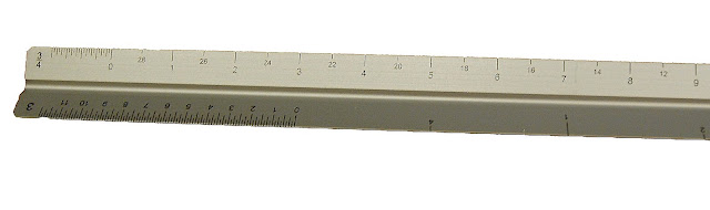 Metal ruler showing measurement markings in inches and centimeters on white background