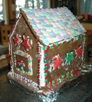 Colorful gingerbread house decorated with icing, candy, and pink flowers