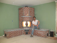 Man standing in front of unfinished brick fireplace with green painted walls