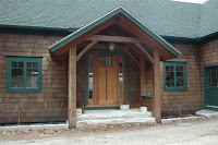 Brick church building with wooden arched entry door and green shutters