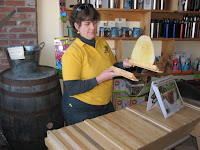 Person in yellow shirt working on wooden project at workshop table