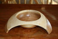 Wooden bowl with curved dome shape on brown surface