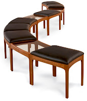 Three mid-century modern wooden benches with brown cushioned seats arranged in a staircase formation.
