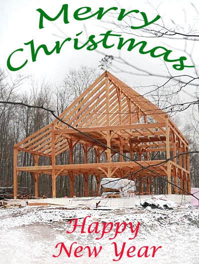 Wooden house frame under construction in snowy landscape with Merry Christmas and Happy New Year text