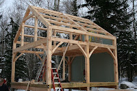 Wooden timber frame pavilion structure under construction in snowy winter setting