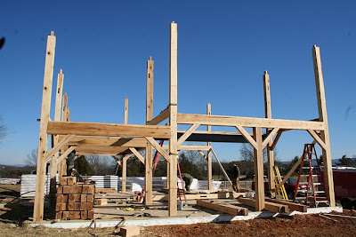 Wooden timber frame structure under construction against clear blue sky