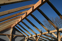 Wooden beam construction against blue sky during building frame assembly