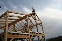 Wooden construction frame structure against cloudy sky and mountains