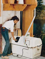 Man sorting trash into white compost bins in front of wooden building