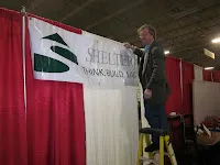 Man speaking at podium in front of Iraqi flag at official event