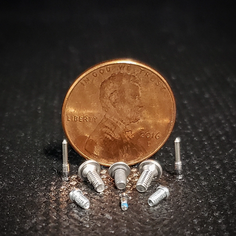 Small fasteners coated with tec-Slip with a penny for size reference