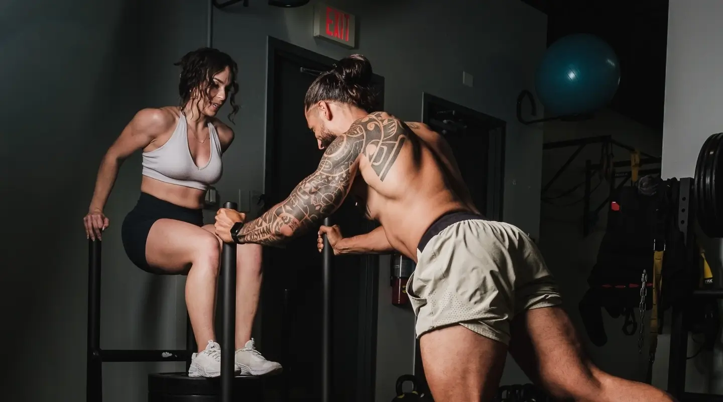 A man and woman exercising together in a gym at CrossFit 812 in Vincennes, IN, showcasing teamwork and fitness.