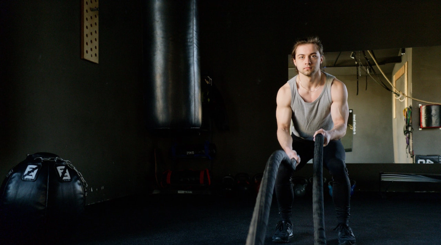 A man holds a rope during a CrossFit session at CrossFit 812 in Vincennes, IN, showcasing strength training techniques.