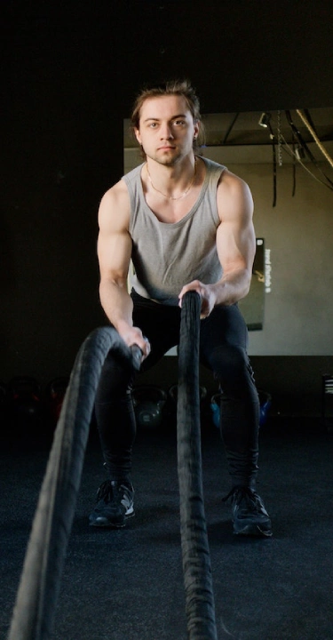 A man holds a rope during a CrossFit session at CrossFit 812 in Vincennes, IN, showcasing strength training techniques.