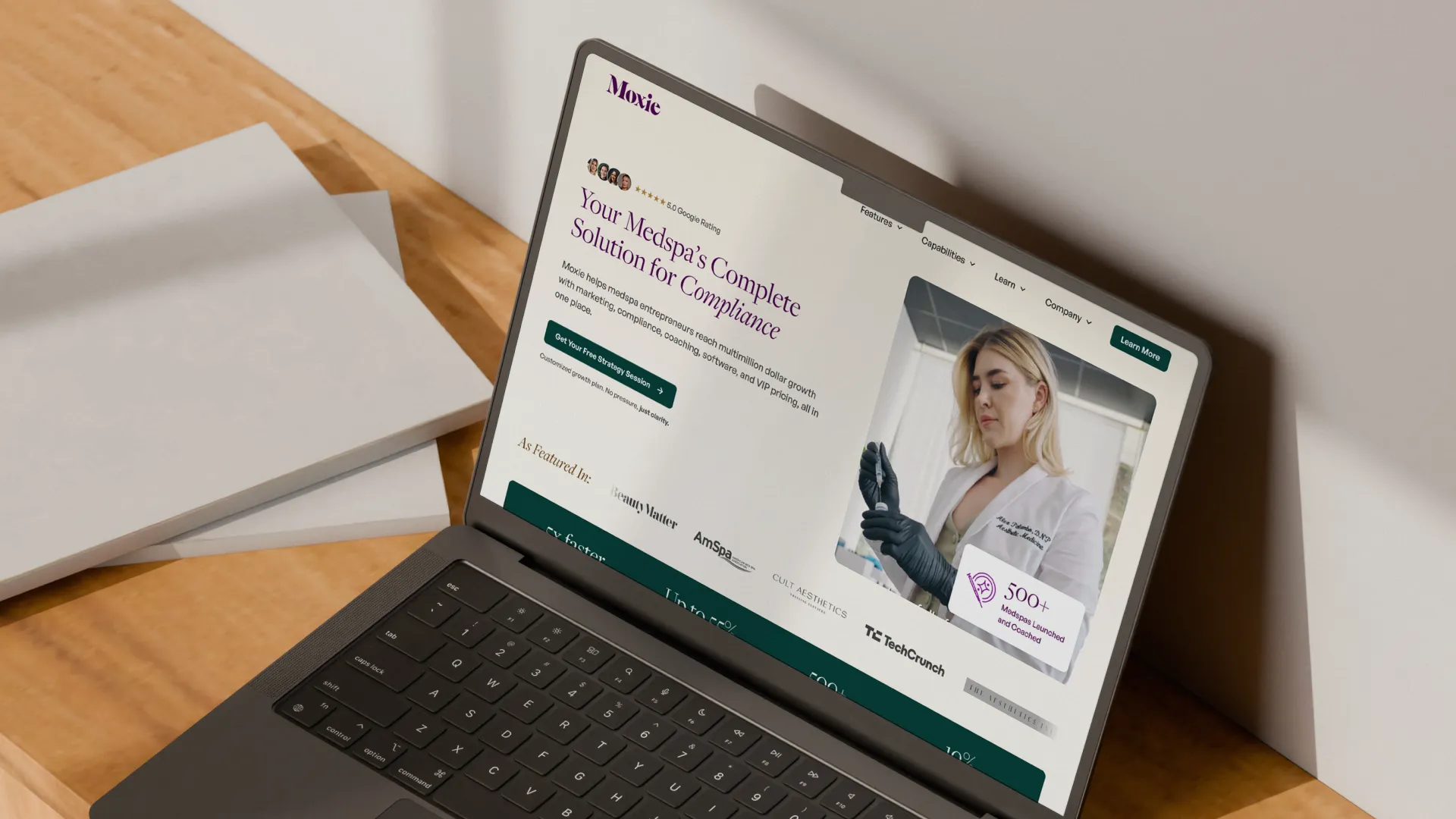 Laptop on a pedestal displaying Fringe website with lifestyle benefits and logos for Hulu, UrbanSitter, and Hotels.com on a purple background.