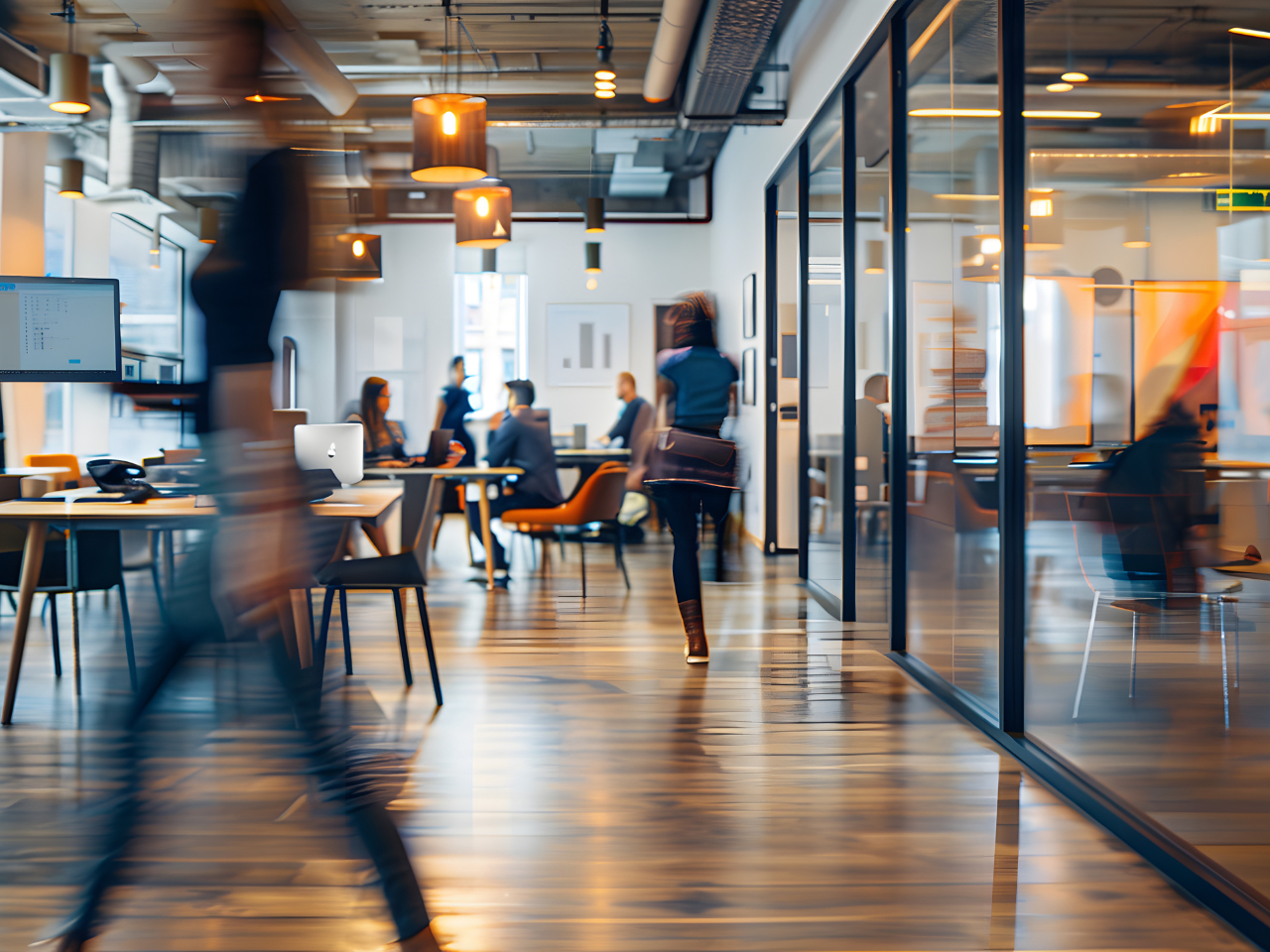 Blurred office with people working behind glass wall