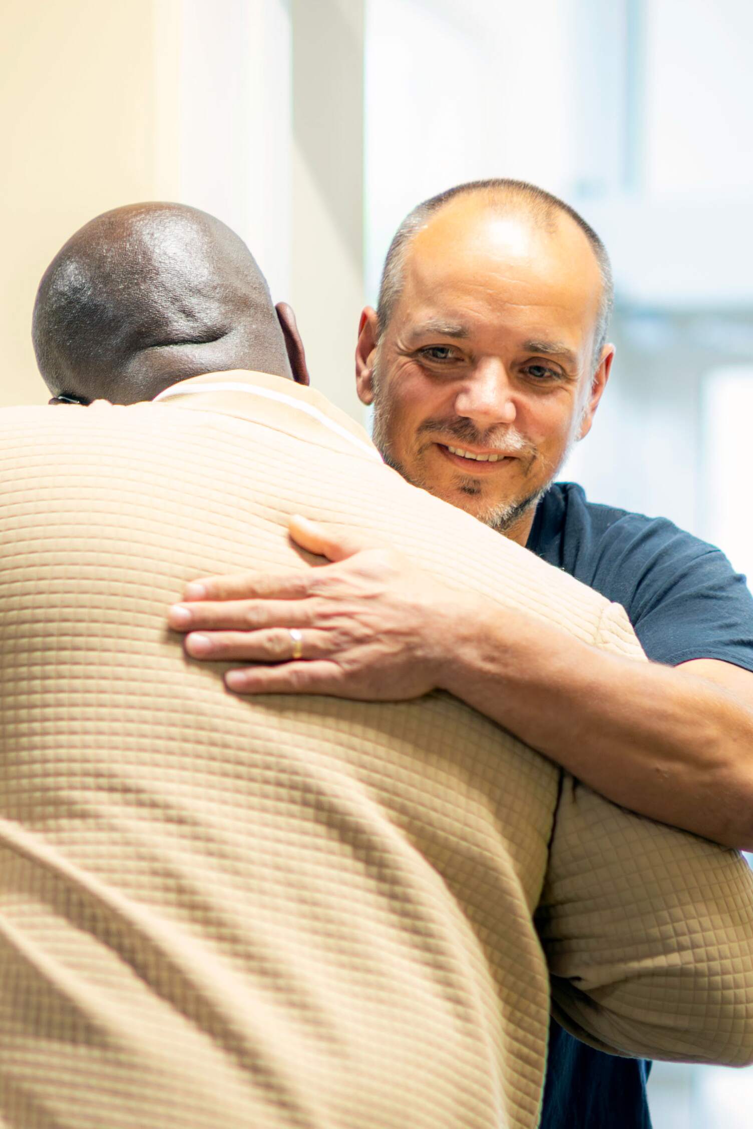 A man hugging another man.