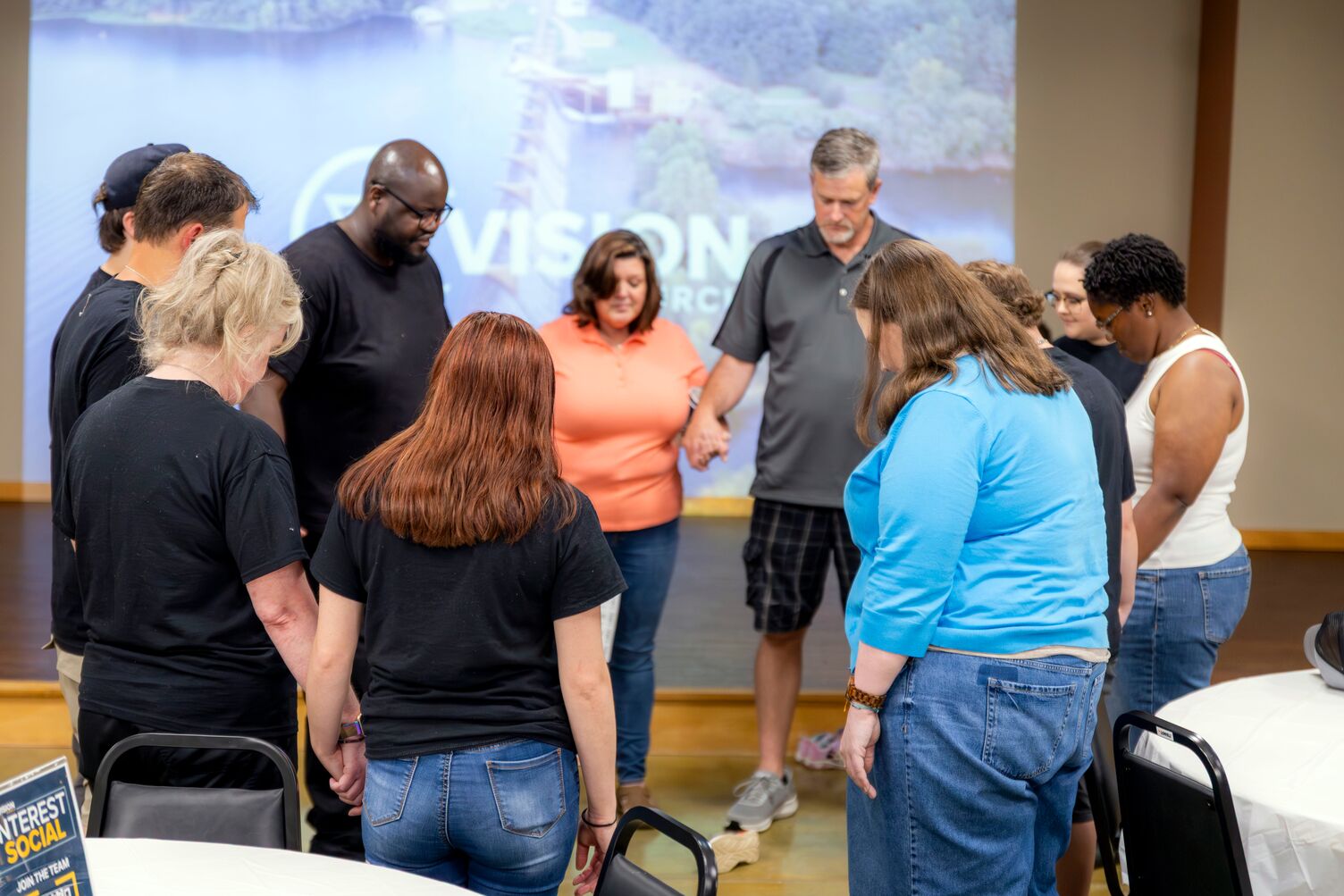 A group of people holding hands in a circle praying