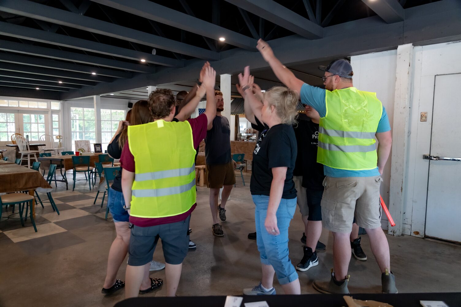 A group of people high fiving each other in a huddle.