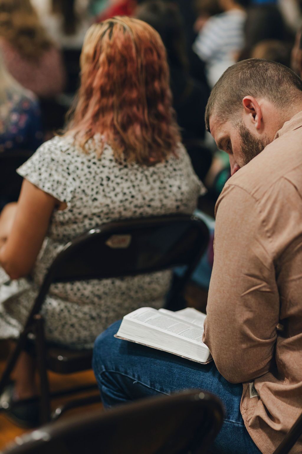 A man sitting in a chair reading his bible