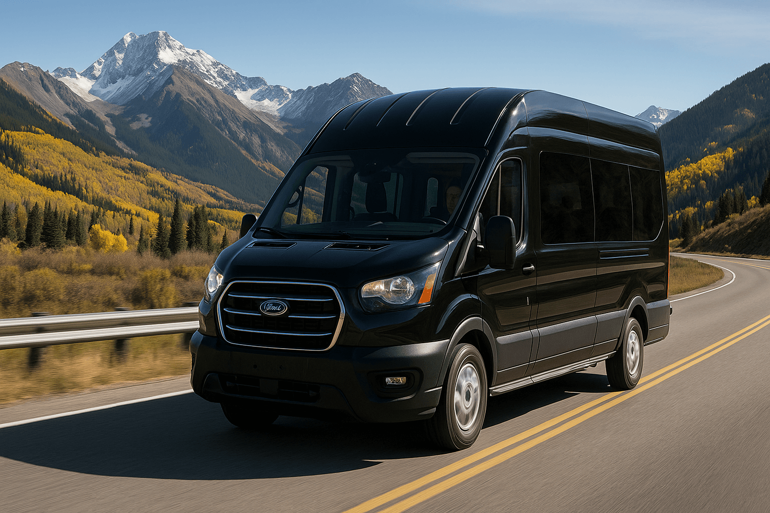 Black Ford Transit van driving on a mountain road with autumn trees and snow-capped peaks in the background.