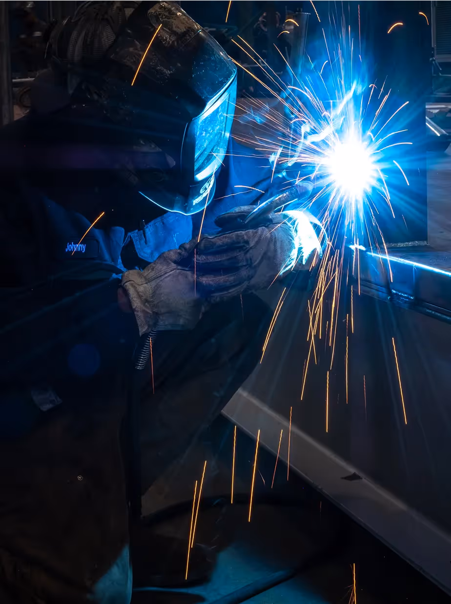 Close-up of a technician welding while wearing protective gear.