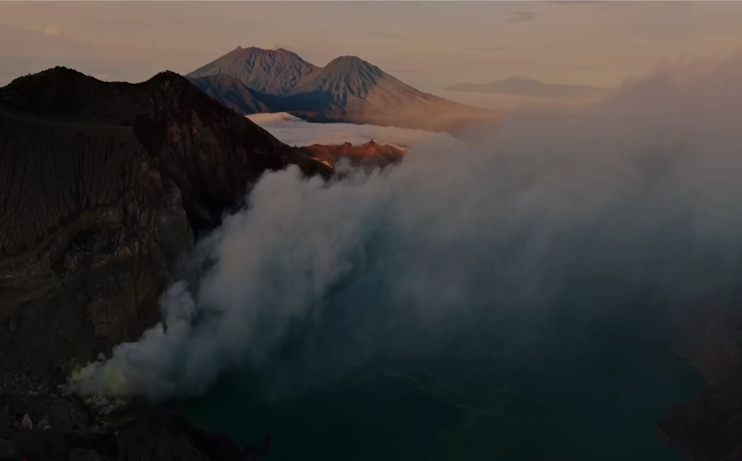 Aerial view of a steaming volcanic crater lake, evoking Crusoe’s focus taking an energy-first approach to AI.