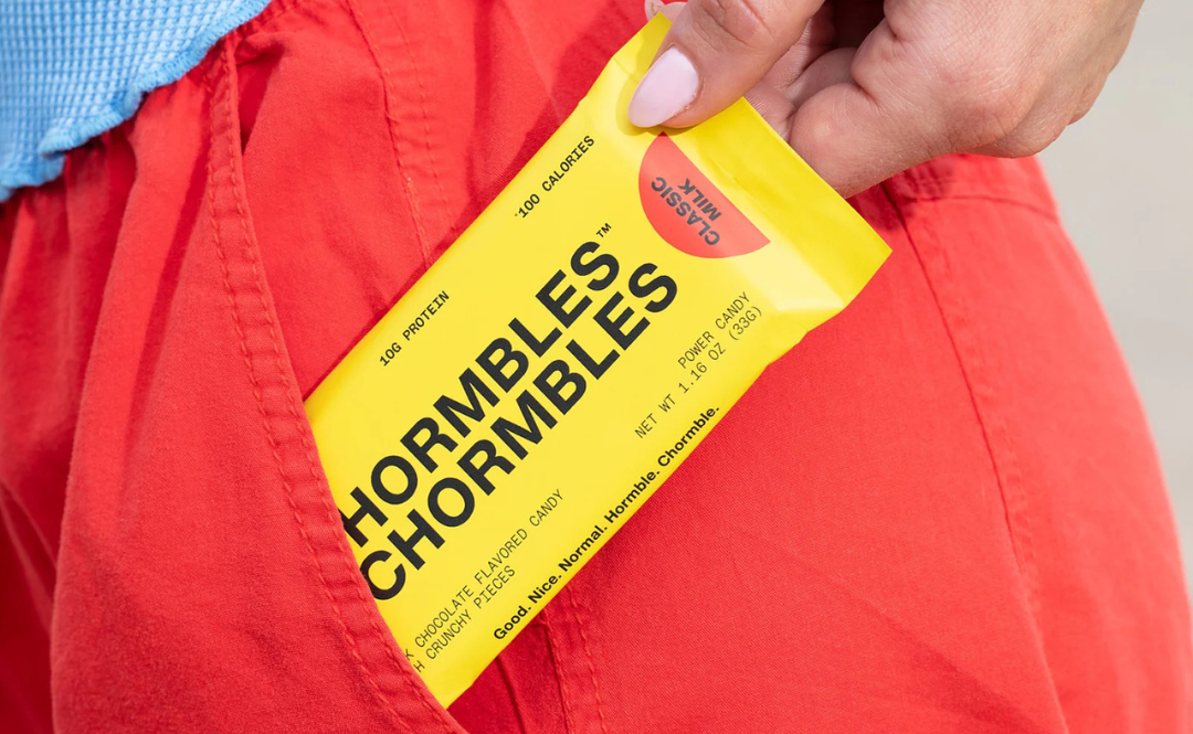 A woman pulling a Hormbles Chormbles candy bar out of the back pocket of her pants