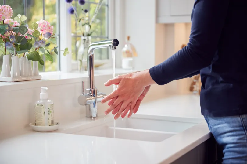 Woman washing hands in sink