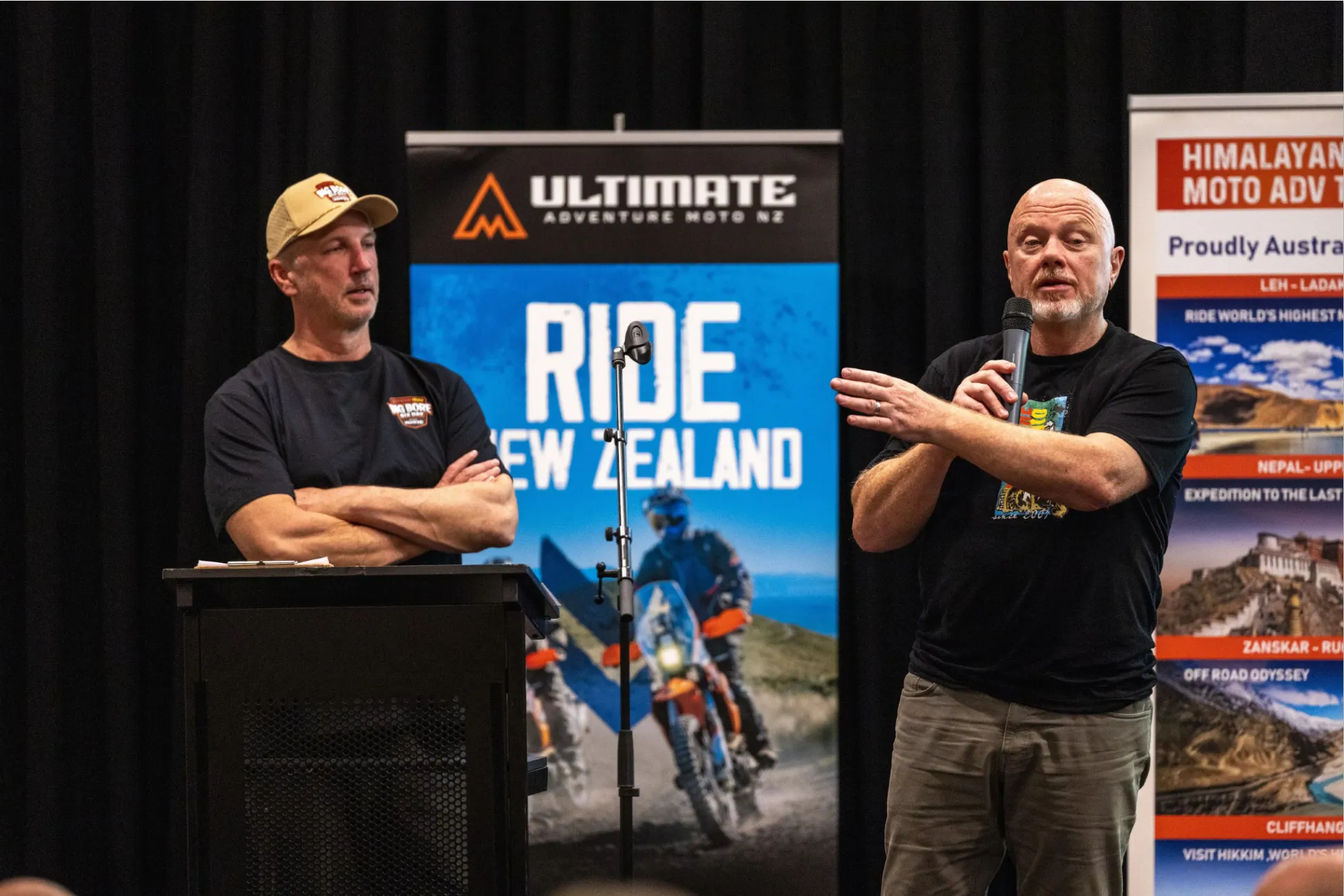 Two people standing on stage addressing a group